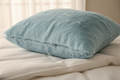 babyblue faux fur pillow throw cover with hidden zipper closure sitting on bed